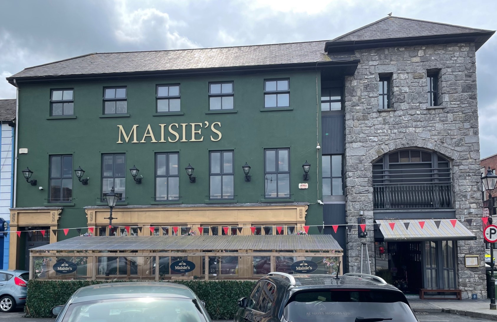 Maisie's pub front with hanging flower baskets.