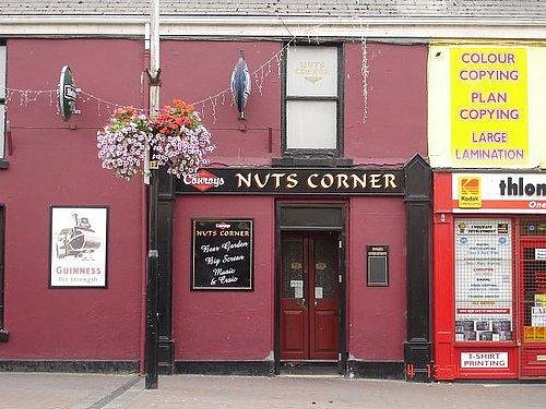 Nuts Corner pub sign lit up at night.